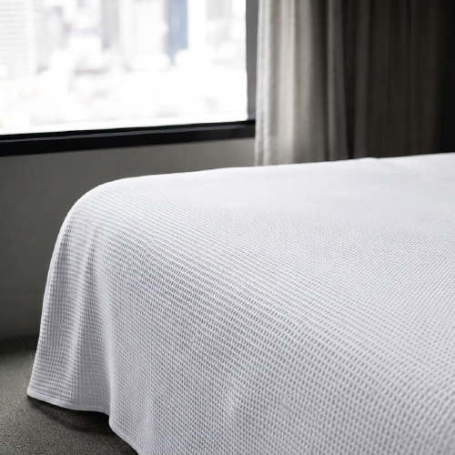 Manta blanca de algodón sobre cama, fabricación española